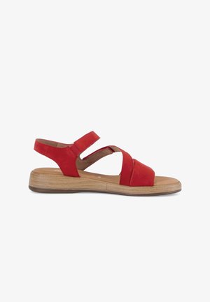Red open-toe sandal with two straps over the foot and an adjustable ankle strap, featuring a low wooden-effect sole.