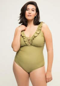 Maillot de bain une pièce vert olive avec des bretelles volantées, décolleté en V profond et détails en croix sur la poitrine ; tissu lisse et extensible.