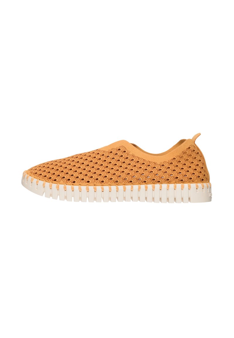 Zapatilla de color naranja claro tipo slip-on con una parte superior texturizada y tejida que presenta un patrón de ondas y una suela de goma blanca con surcos horizontales.
