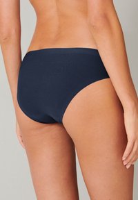 Slip bikini in color blu navy, con design a vita media. Tessuto liscio con taglio arrotondato sul retro e senza chiusure o decorazioni visibili.