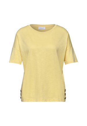 Einfaches hellgelbes T-Shirt mit kurzen Ärmeln, rundem Ausschnitt und drei dekorativen Knöpfen auf der linken Seite nahe dem Saum.