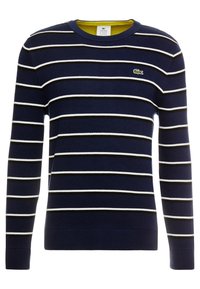 Tmavě modrý svetr s horizontálními bílými a černými pruhy. Má žebrovaný kulatý výstřih a manžety. Na hrudi vyšívané logo Lacoste.