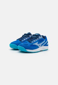 Chaussures de sport bleues avec une tige en maille, présentant un logo accentué en blanc, une semelle texturée et des détails turquoise contrastés.