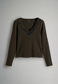 Dlhý rukáv hnedého topu s hlbokým výstrihom do V lemovaným čiernou čipkou. Tkanina má rebrovanú štruktúru a voľný strih.