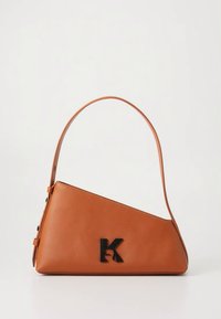 Ljusbrun läderhandväska med en kantig design och en enkel axelrem. Har en svart "K"-logotyp på framsidan. Slät yta.