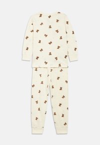 Set di pigiami color crema con maniche lunghe e pantaloni, caratterizzato da un motivo ripetuto di orsacchiotti e accenti a forma di stella, realizzato in morbido cotone.