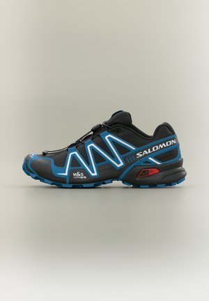 Czarny but do biegania po szlakach z niebieskimi akcentami, wyposażony w teksturowaną cholewkę, wyraźny bieżnik zapewniający przyczepność, elementy odblaskowe oraz regulowany system sznurowania.