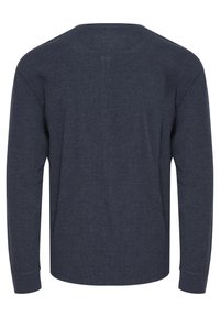 Hosszú ujjú, crew neck póló sötét tengeri kék színben, texturált anyagból, laza szabással és egyenes aljjal. Egyszerű dizájn, látható grafikák nélkül.