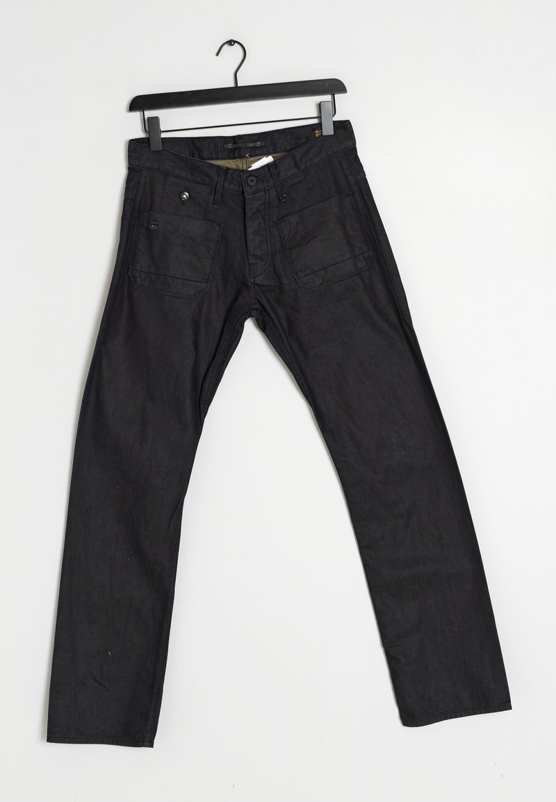 Black denim pants with a straight leg design, five pockets, metal hardware, and slight texture. Hangs on a black plastic hanger.