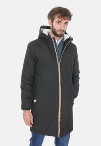 Cappotto isolato nero con cappuccio, caratterizzato da una cerniera multicolore in contrasto, tasche laterali e una morbida fodera interna. Tessuto dalla superficie liscia.