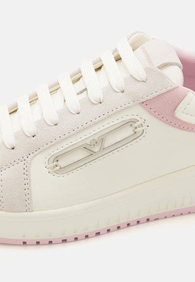 Witte leren sneaker met roestkleurige accenten, suède overlays en een logo aan de zijkant. Voorzien van platte veters en een rubberen zool met een gestructureerd patroon.