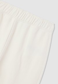 Pantaloni sportivi bianchi in cotone con una vita elastica arricciata e una superficie liscia. Presentano cuciture laterali, senza tasche visibili o motivi.