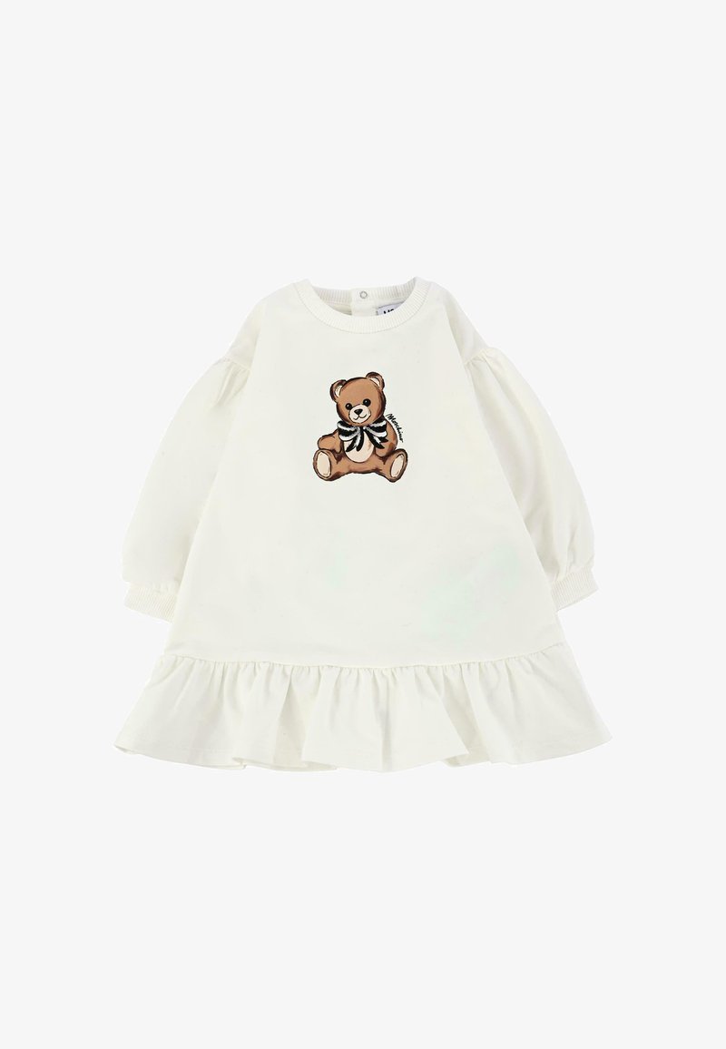 Biała sukienka z bufkami i falbanką. Na przedzie znajduje się grafika brązowego misia pluszowego z czarno-białą kokardą.