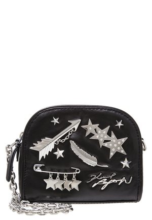 Schwarze Tasche aus synthetischem Leder mit silbernen Stern- und Federverzierungen, Kettenriemen und geschwungenem Design. Verfügt über einen Reißverschluss und dekorative Elemente.