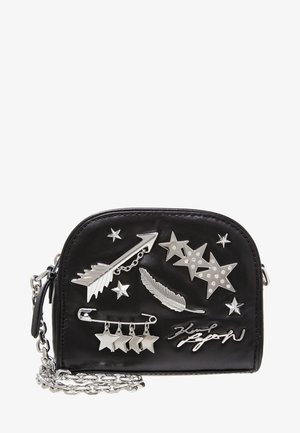 Bolso de cuero sintético negro con adornos de estrella y pluma plateados, correa de cadena y diseño curvo. Cuenta con cierre de cremallera y elementos decorativos.