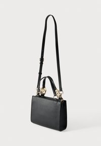 Μαύρη δερμάτινη τσάντα χειρός με υφή. Διαθέτει δύο χερούλια στο πάνω μέρος και ένα μακρύ ρυθμιζόμενο λουρί, με χρυσές μεταλλικές λεπτομέρειες.