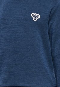 Mörkblå sweatshirt i en texturerad tyg. Har en liten broderad bi-logotyp i vitt, placerad på den övre vänstra sidan.