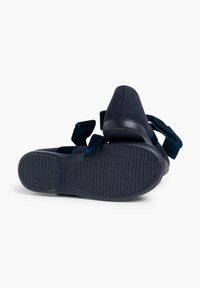 Sandalias azul marino con un upper suave, dos tiras ajustables de velcro y una suela de goma texturizada para un mejor agarre. Detalles de acabado en el talón.
