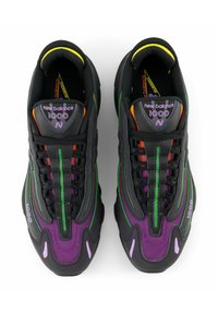 Des baskets noires avec des accents violets, verts et oranges, dotées d'un dessus en maille et en caoutchouc, d'une semelle épaisse et d'un système de laçage visible.