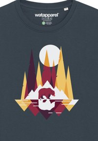 Donkerblauwe t-shirt met een gestileerde beer op ijs, omgeven door geometrische rode, gele en witte bomen en een cirkelvormige zon.