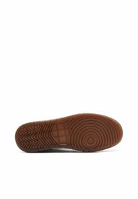 Semelle en caoutchouc avec une surface brune texturée, présentant des motifs circulaires et en zigzag, conçue pour l'adhérence et le soutien.