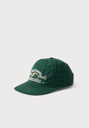 Casquette de baseball vert foncé avec texte blanc brodé et un motif arc-en-ciel sur le panneau avant, présentée sur un fond clair uni.