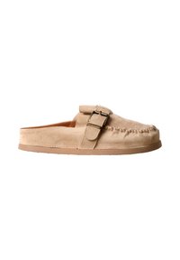 Mocassin beige en daim à enfiler avec détail cousu sur le bout et bride ajustable avec boucle métallique, semelle plate en caoutchouc et talon ouvert.