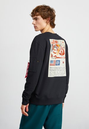 Black sweatshirt featuring a graphic print on the back, with text and flags. Includes textured panel on the sleeve and a red tag.