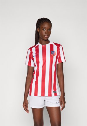 Rood en wit gestreepte voetbalshirt met korte mouwen, een kraag en het logo van Atlético Madrid. Gecombineerd met witte shorts met een Nike-logo.