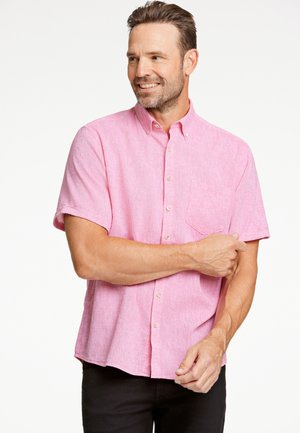 Camisa de manga corta, con botones, en tejido de color rosa claro con una textura sutil; cuenta con un bolsillo en el pecho y un cuello clásico.
