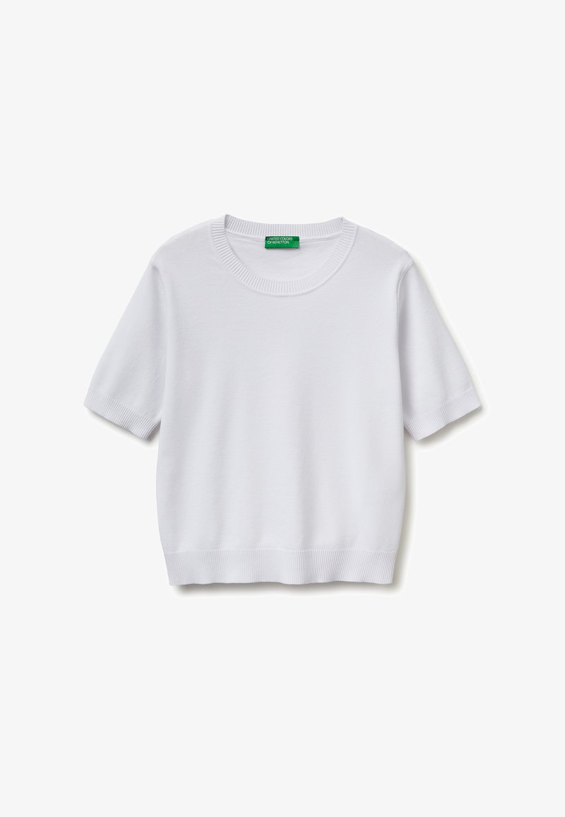 Pull blanc à manches courtes en maille avec col rond côtelé, poignets et ourlet, doté d'une étiquette verte à l'intérieur du col.