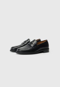 Black leather loafers with a smooth finish, featuring a stitched design and a raised band across the top. Flat rubber sole.