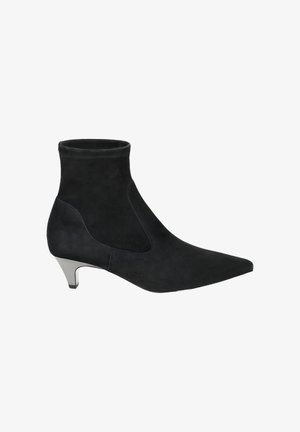 Bottines en suede noir avec un bout pointu et un talon de hauteur intermédiaire. Présentent une texture lisse et un design épuré, avec des panneaux latéraux élastiques.