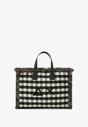 Borsa tote a scacchi bianco e nero con bordi sfilacciati, dotata di manici in pelle nera e un logo al centro. Texture e design distintivi.