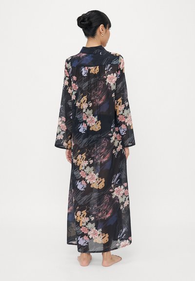 Caurspīdīgs melns kimono ar ziedu rakstu rozā, dzeltenā un baltā krāsā. Garas piedurknes, pogājams apkakle un garumu līdz potītei ar plūstošu tekstūru.
