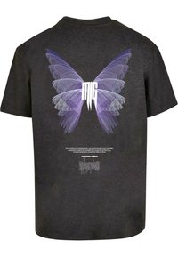Camiseta negra con un gran gráfico de mariposa púrpura en la parte posterior y texto blanco. Tejido suave con un ajuste relajado y mangas cortas.