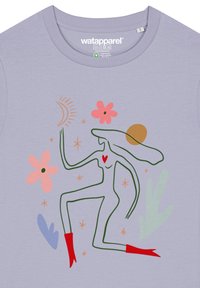 Lila katoenen t-shirt met een gestileerde groene figuur, rode laarzen, een rood hart, roze bloemen en hemelse ontwerpen.
