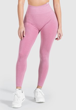 Hoge taille roze leggings met een gladde textuur, met een getailleerd silhouet. Gecombineerd met witte sport schoenen.