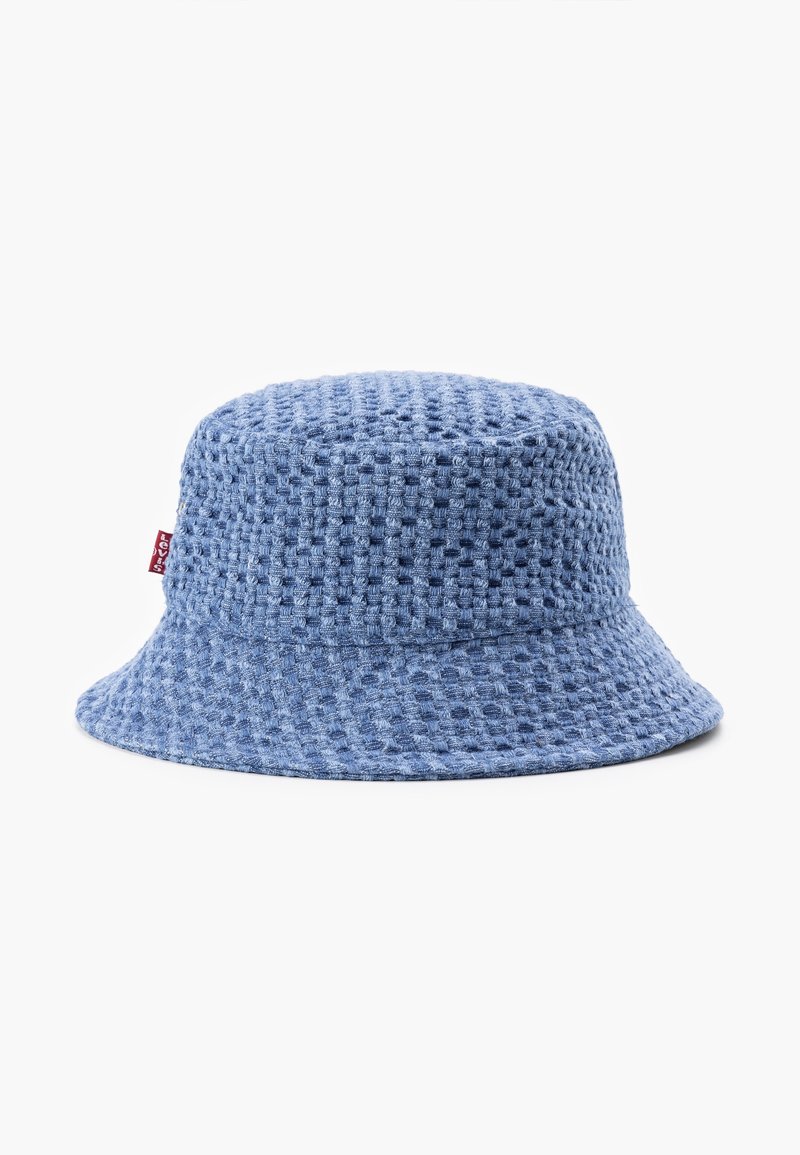 Bob en tissu bleu texturé avec un motif à carreaux subtil et une petite étiquette rouge sur le côté.