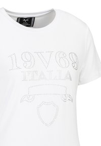 White cotton T-shirt featuring silver rhinestone embellishments that spell "19V69 ITALIA." Round neckline, short sleeves, and smooth texture.