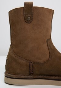 Ruske antilop čizme do gležnja sa zaobljenim vrhom, malim petljom na vrhu i kontrastnim šavom duž strane i đona.