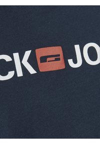 Navy blue cotton T-shirt with a visible logo featuring white text and a red square accent on the front. Smooth texture and casual design.