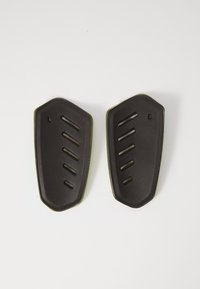 Protezione in gomma nera con superficie texture, caratterizzata da scanalature diagonali e un bordo verde, progettata per attrezzatura protettiva.