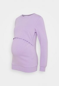 Graviditetströja i ljuslila, med en rundad halsringning, långa ärmar och en rynkad panel för att rymma en växande mage.