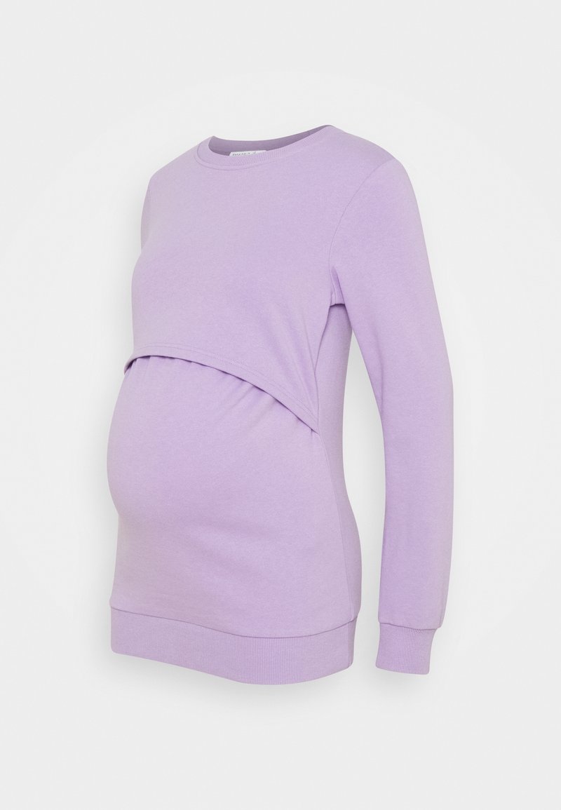 Graviditetströja i ljuslila, med en rundad halsringning, långa ärmar och en rynkad panel för att rymma en växande mage.