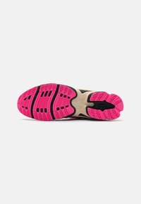 Athletic shoe outsole with textured pink rubber, featuring drainage grooves and a black accent line, designed for traction and flexibility.