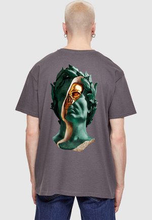 Graues Baumwoll-T-Shirt mit einem grafischen Motiv eines grünen und goldenen Büsten Designs auf der Rückseite, das klassische und zeitgenössische Elemente verbindet.