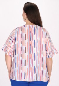 Bluse med blomstermønster i pink, blå og hvide lodrette striber. Korte flæseærmer og afslappet pasform.