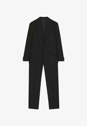 Musta puku, joka koostuu räätälöidystä takista, jossa on lovatut kaulukset ja yksittäiset napit, yhdistettynä suoralahkeisiin housuihin. Sileä kangaspinta.