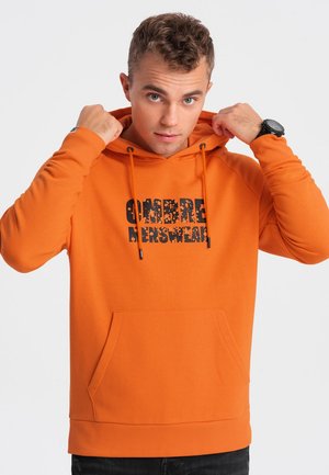 Felpa arancione in misto cotone con tasca a marsupio, cappuccio con coulisse e stampa nera davanti. Vestibilità classica.